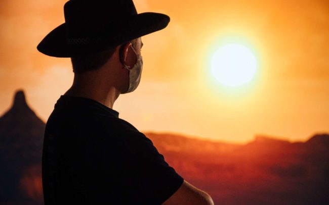 A person with a cowboy hat standing in a canyon in a virtual production studio.