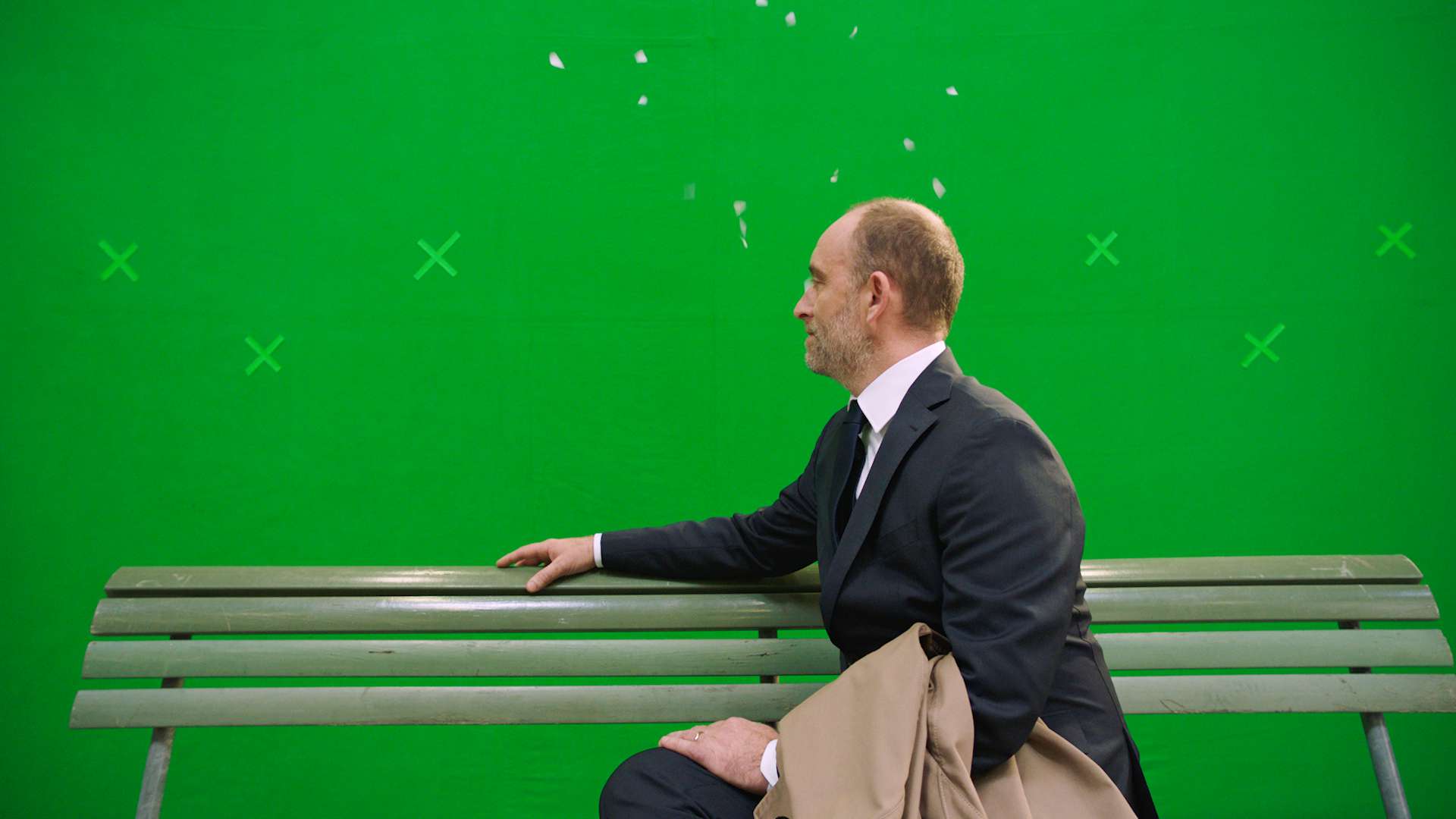 The main actor of the bank avera commercial sitting infront of a empty greenscreen.