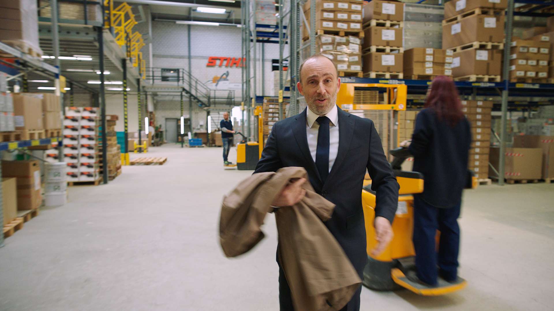 The main actor of the bank avera commercial in the raw footage in a hall of the Stihl gmbh