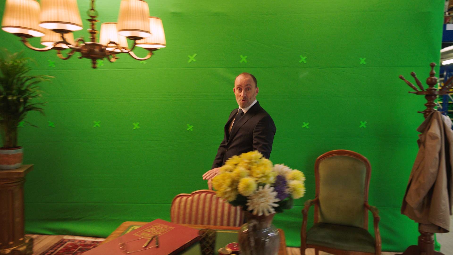 The main actor of the bank avera commercial walking infront of a empty greenscreen.