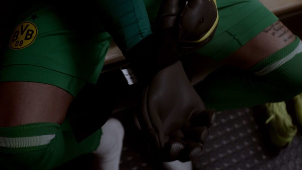 The goalkeeper of the football club Borussia Dortmund putting on his gloves berfore a game.