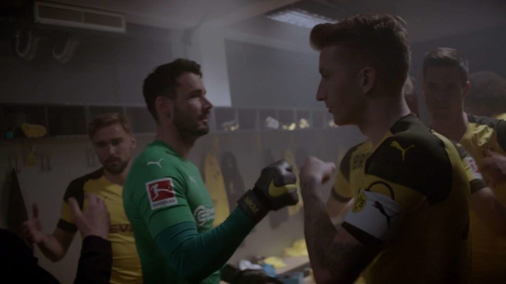 Players of the football club Borussia Dortmund gratulating each other while preparing for a game.