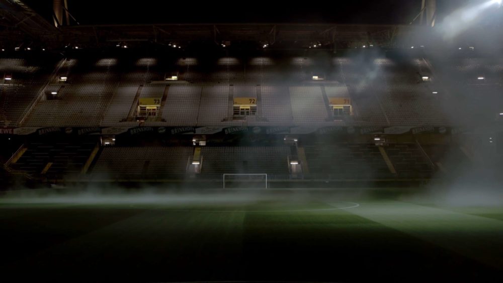 The empty seats of the Signal Iduna Park of the football club BVB at night and with fog.