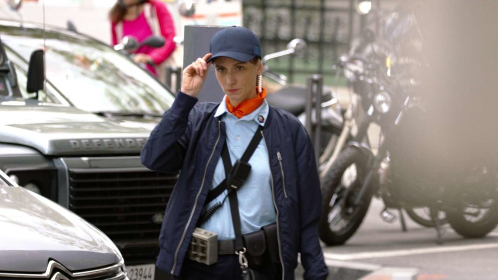 The main actress of the commercial Twint Parking walking on the sidewalk in the city of zurich.