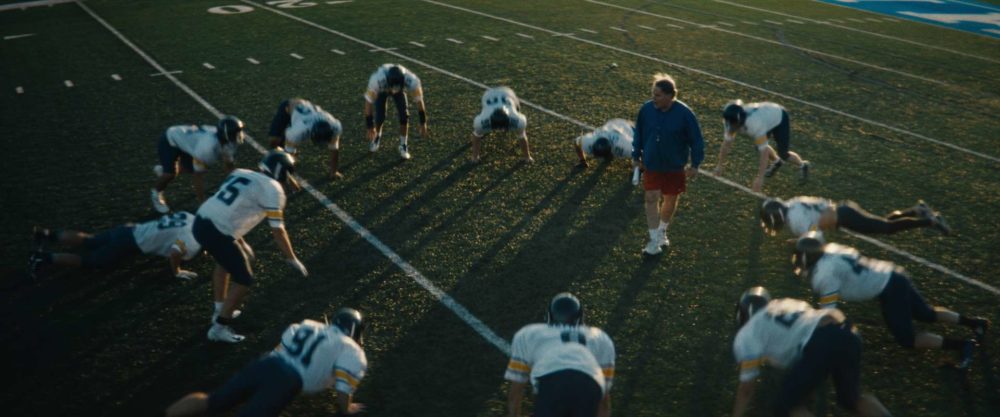 A couple of football players doing push ups on a field in a film with postproduction by Adrian Weber