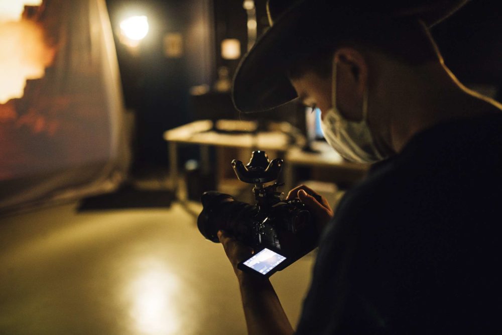 A person holding a GH-5 with a HTC-Vive tracker for virtual production.