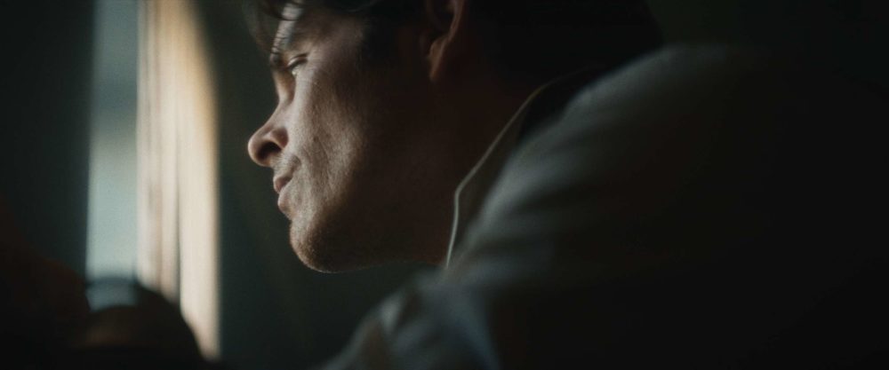 The founder of IWC looking out the window in a dark room.