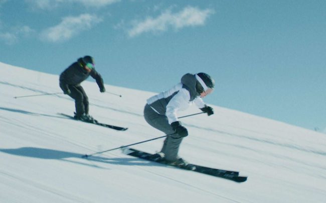 Two skiers going down a slope at high speed for the Made in Bern Commercial