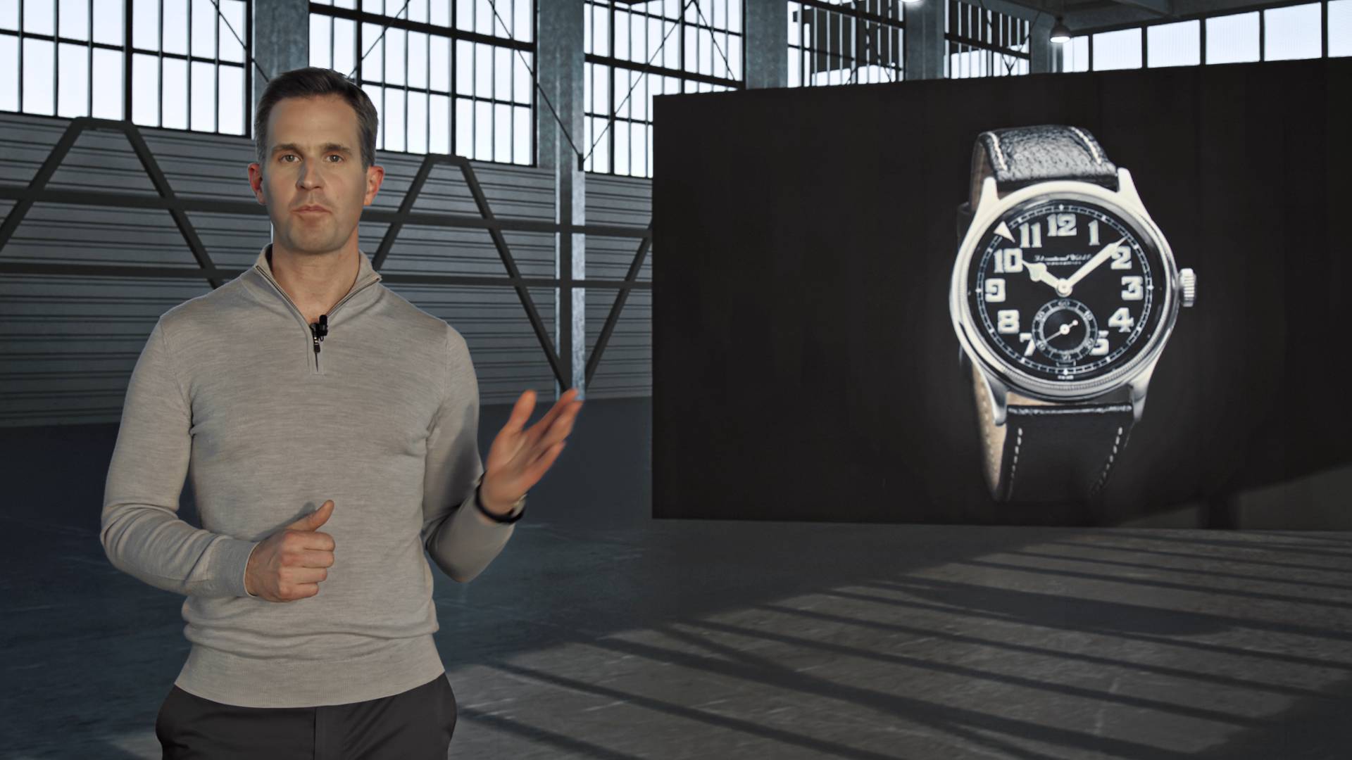 Christopher Grainer Herr, the CEO of IWC, pointing at a watch in a hangar.