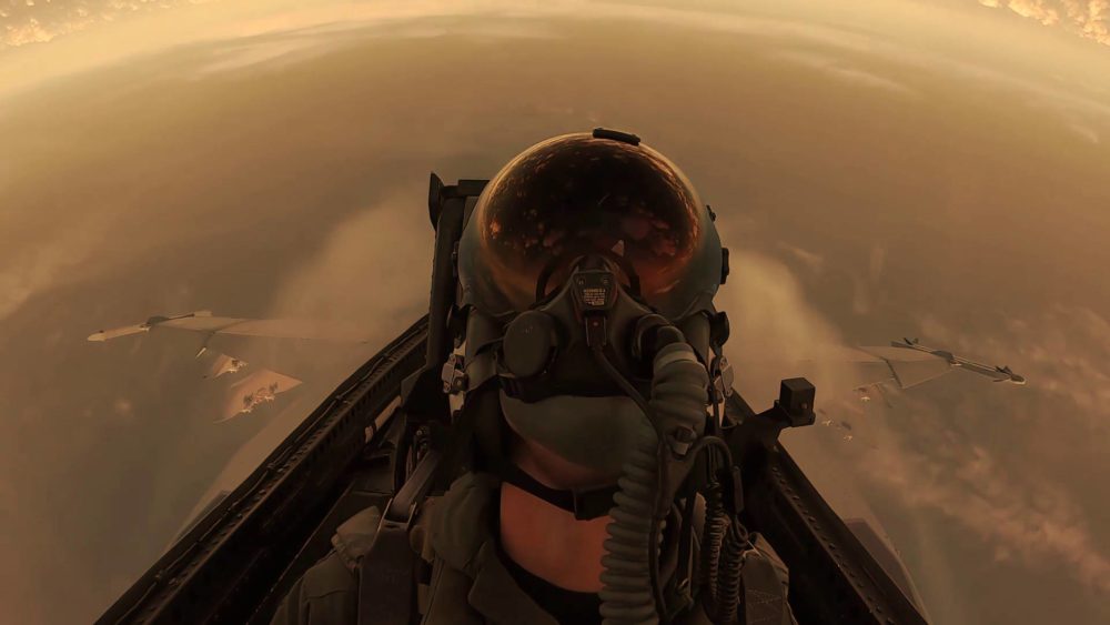 A fighter pilot is doing a harsh maneuver in his cockpit.