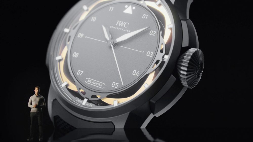 A man is standing in front of a giant watch.